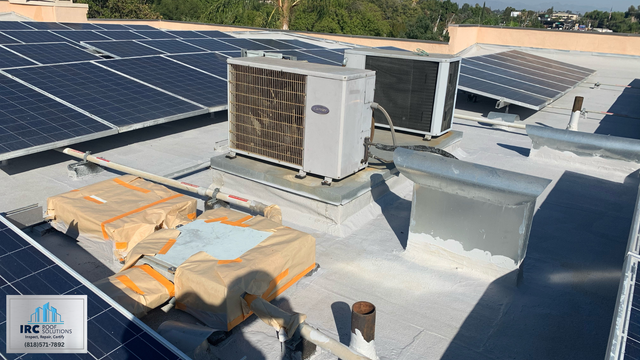 Dark weathered cap sheet on a commercial roof before restoration coating.