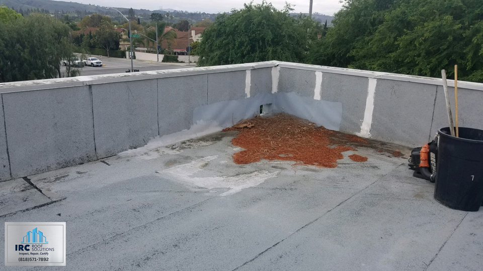 Large commercial roof field with mechanical units and open membrane sections.