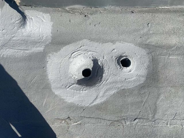 Detail of coating work around a roof penetration on a flat commercial membrane.