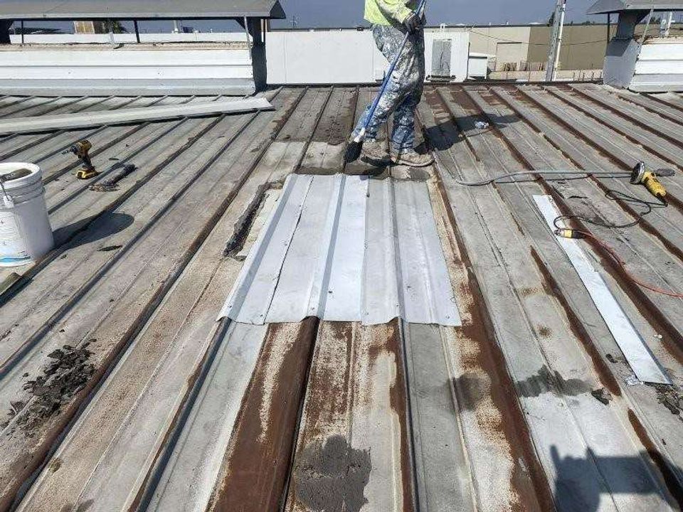 Commercial roof restoration and waterproofing work across a low-slope roof field.